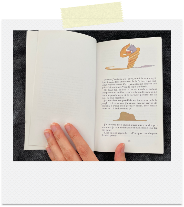 The Little Prince book open to the drawing of an elephant swallowed by a boa constrictor